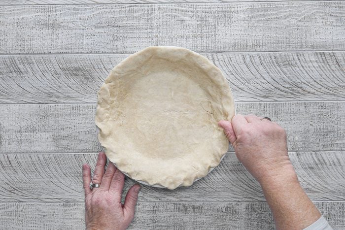 Trimming dough from rim of pie plate