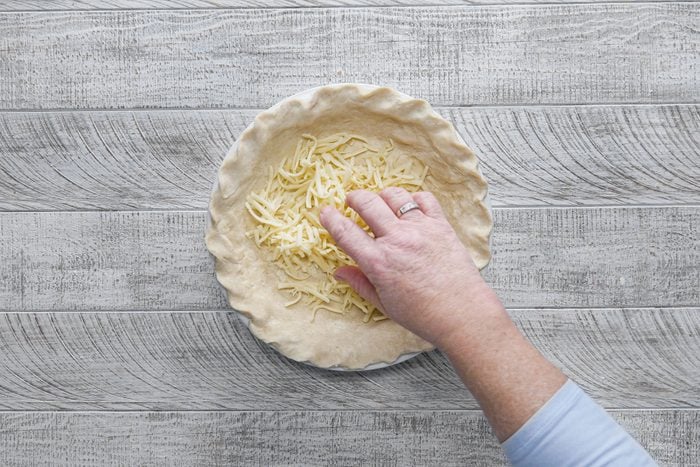 Sprinkling cheese in dough