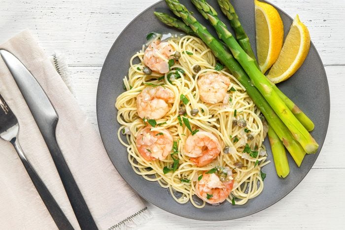 Shrimp Piccata served with beans and lemons in a plate
