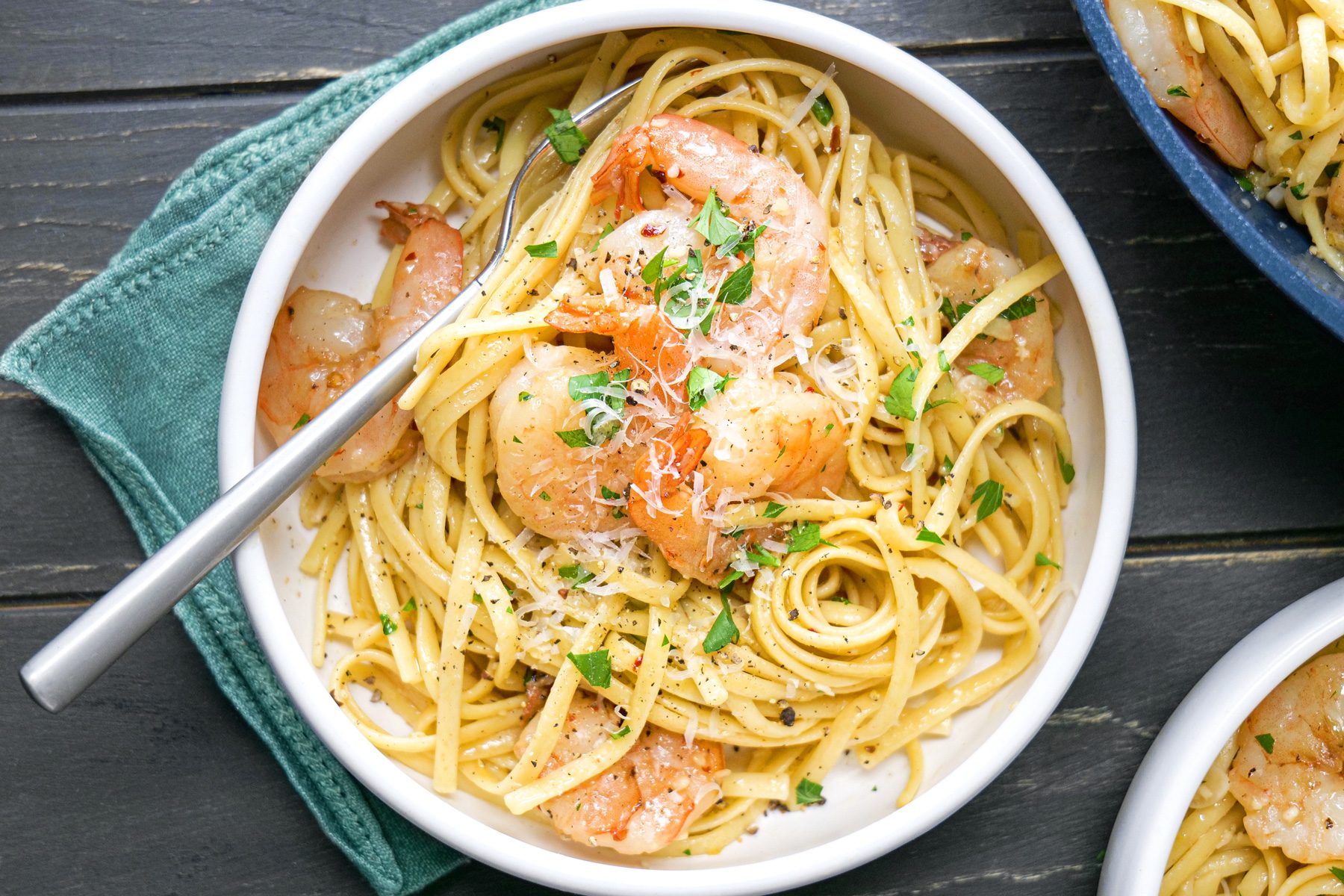 A bowl of pasta with shrimp and parmesan cheese