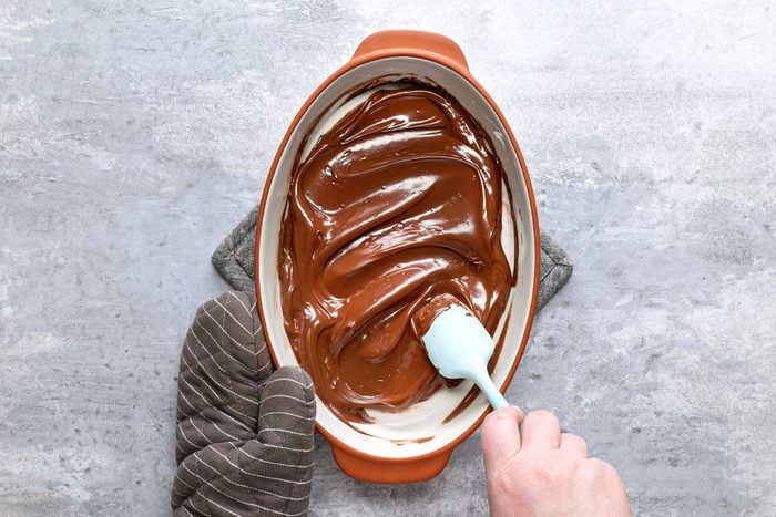 Stirring melted chocolate in baking dish