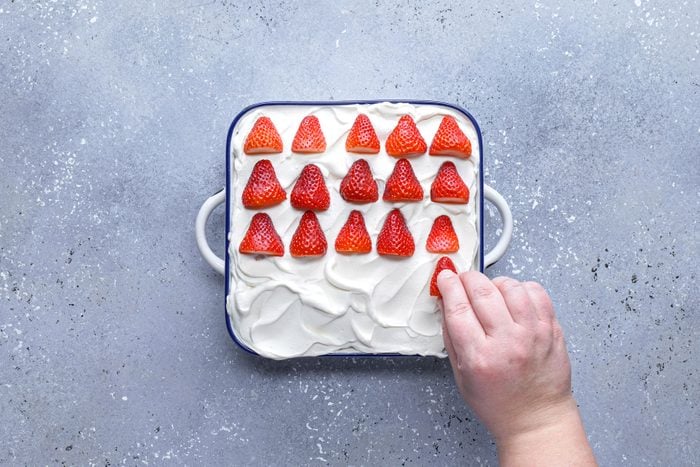 Strawberries arranged on cram mixture in a large pan