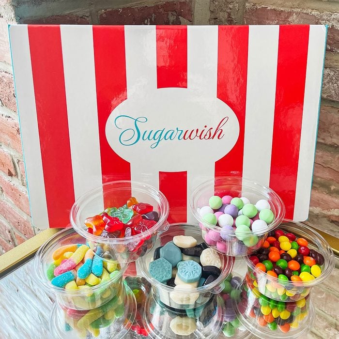 Sugarwish gift box with Containers Of Various Candy Propped In Front Of The Box
