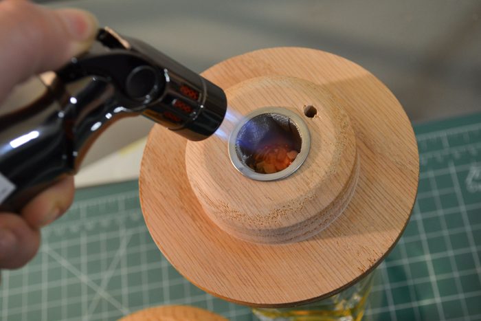Wielding a torch on a wooden surface of a jar