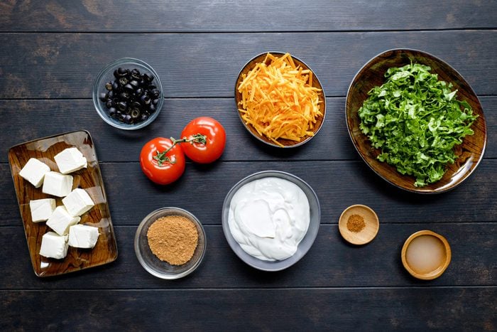 All Ingredients for Taco Dip on Wooden Surface