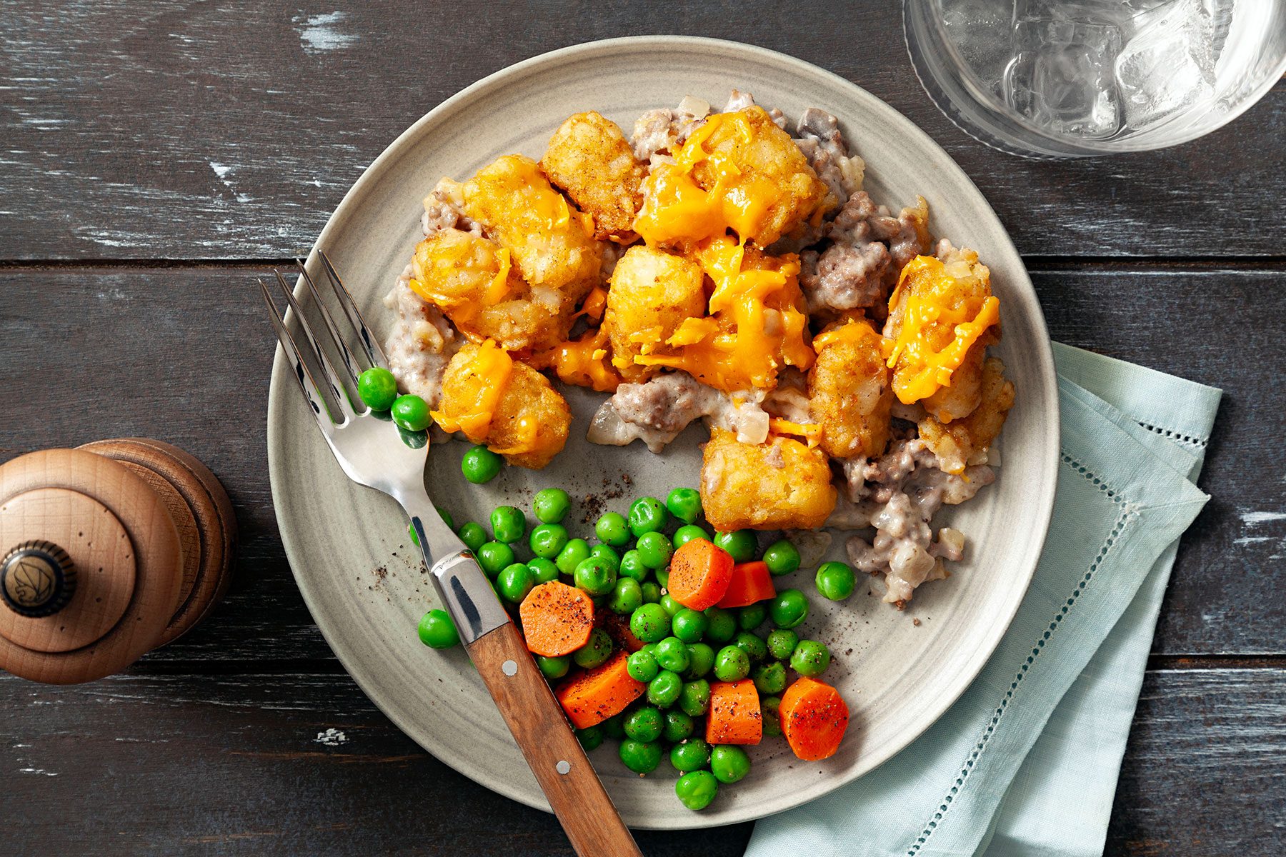 Tater Tot Casserole served on plate with peas and other vegetables 