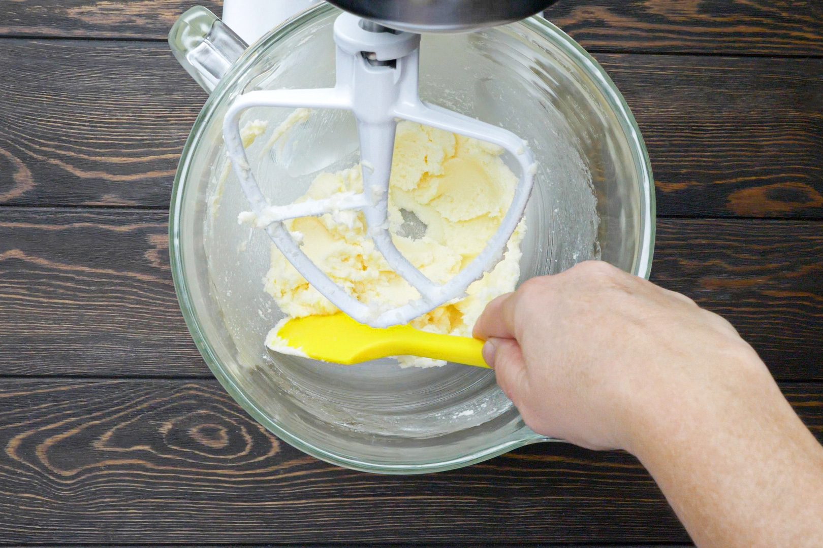 A person creaming the butter and sugar using a hand mixture