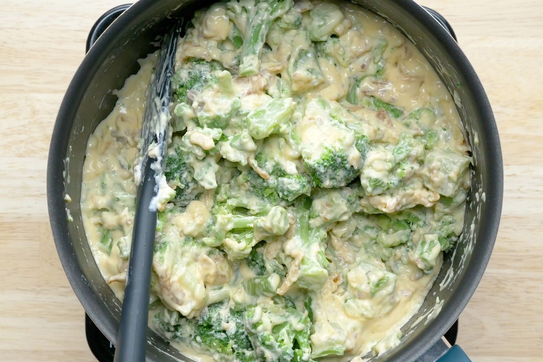 Broccoli mixed with cheese and other ingredients in a saucepan