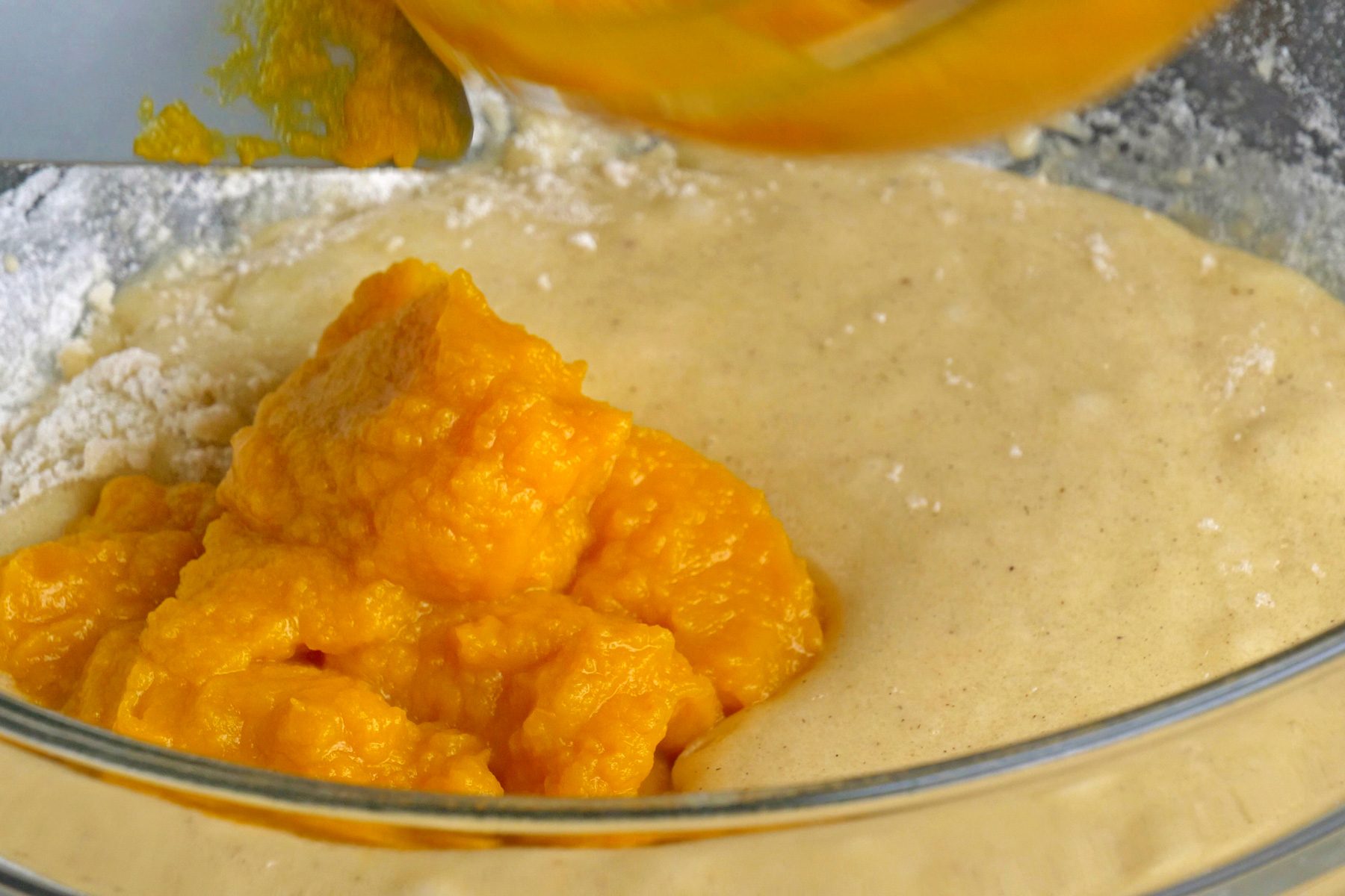 A bowl of wet mixture with canned pumpkin puree